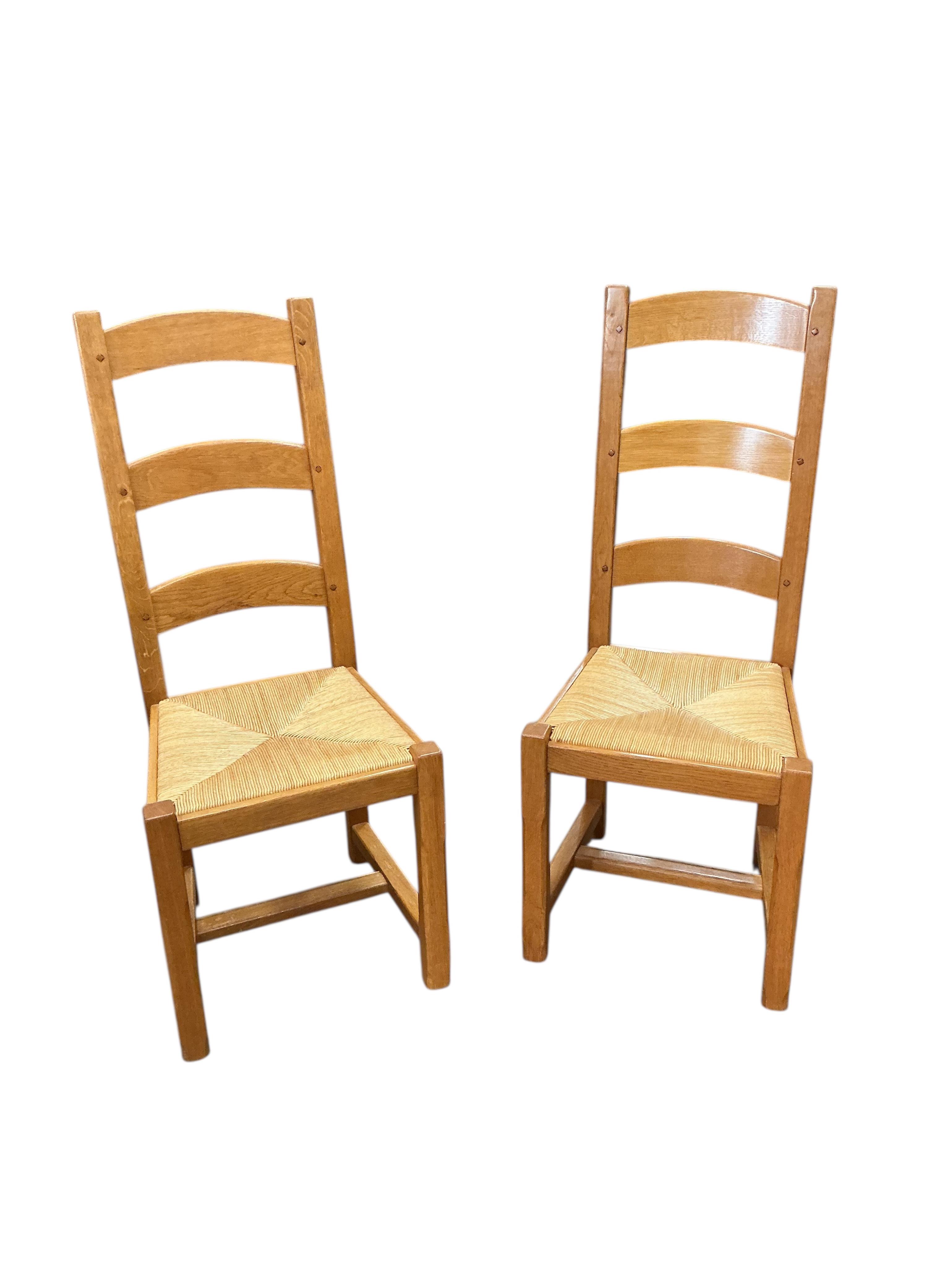 A set of eight contemporary oak rush seat ladderback dining chairs